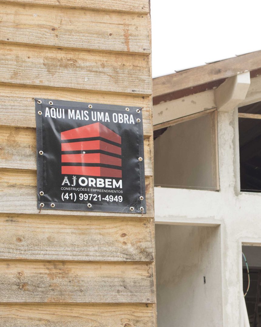 Obra da AJ Orbem em execução, com a placa &ldquo;Aqui mais uma obra&rdquo; na entrada