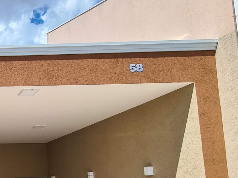 Fachada de residência entregue pela AJ Orbem, com beiral em ângulo e acabamento em textura